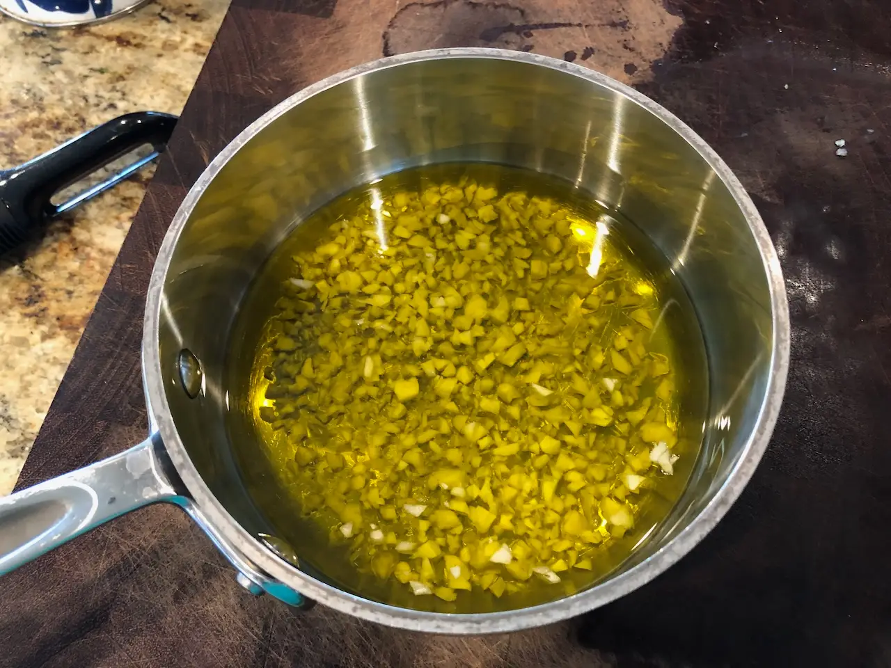 Garlic and EVOO in a small pot - infusing the garlic into the oil