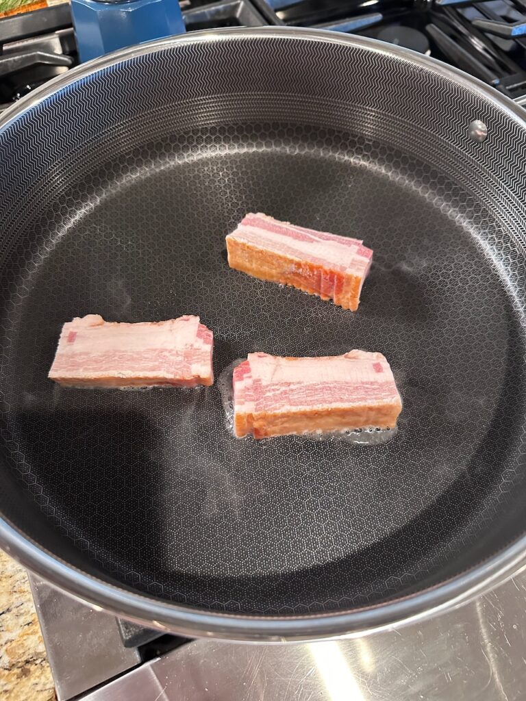 Frozen bacon into a large fry pan 