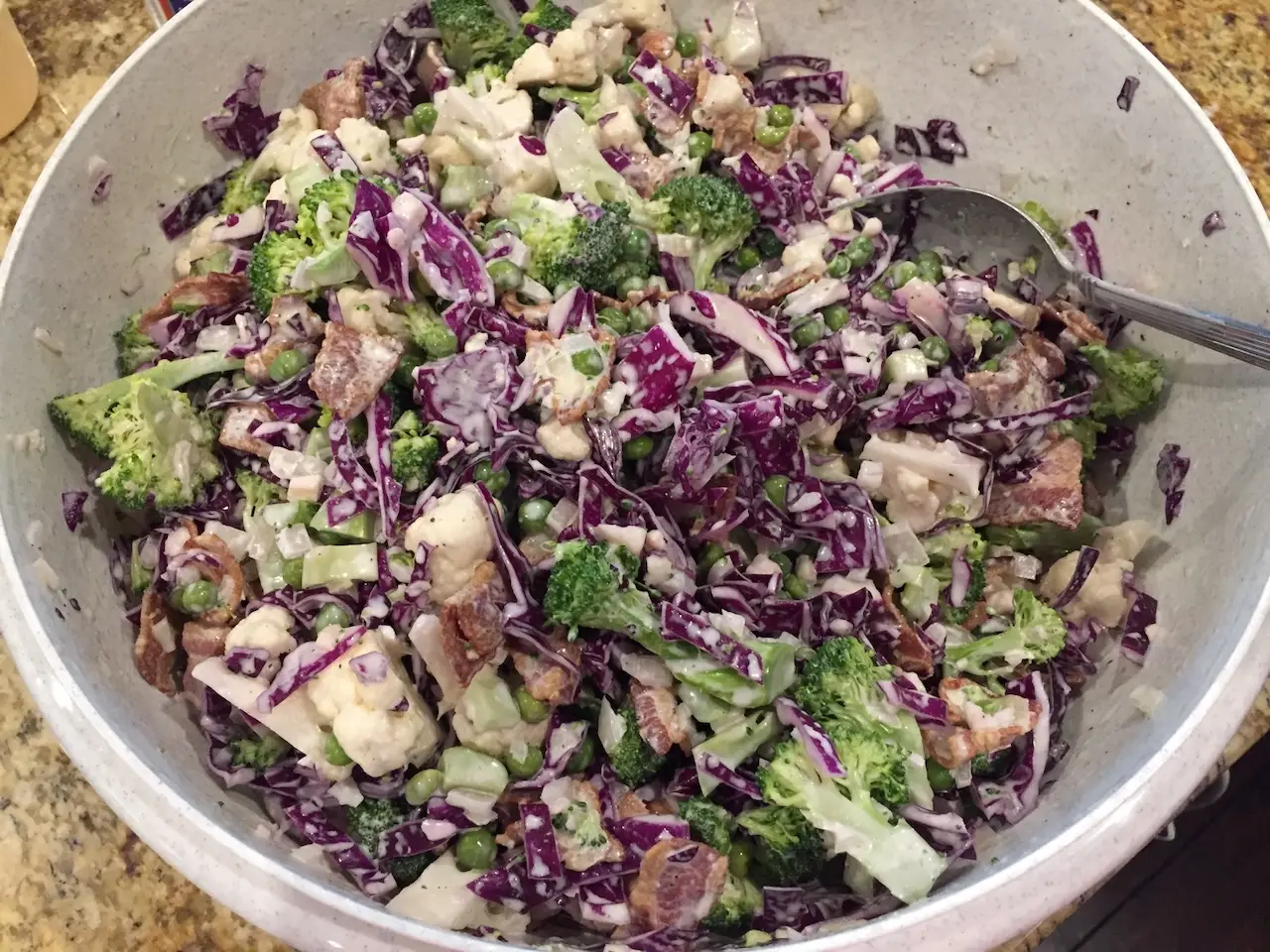 Huge bowl of broccoli, cabbage, cauliflower, bacon and peas - dressed in a tangy mayo and cheese dressing
