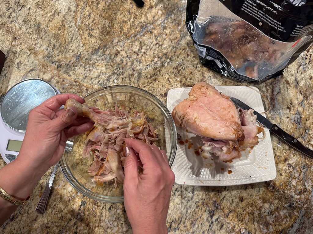 Me pulling the chicken and separating the bones and carcass from the meat.