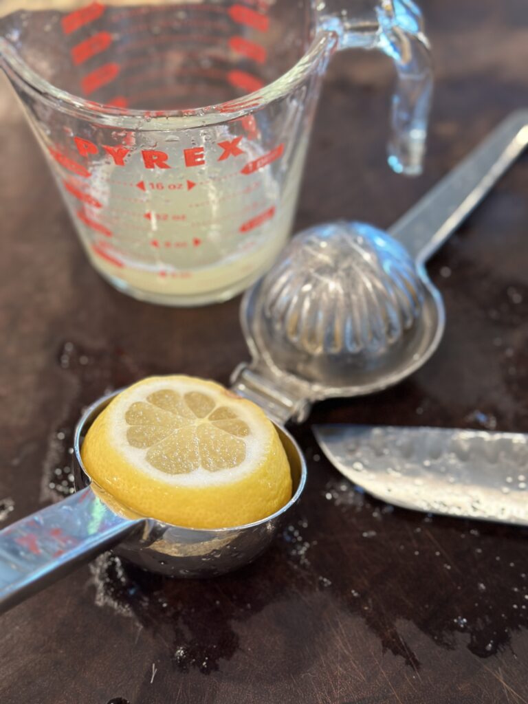 Showing how to place the lemon large cut side down into the juicer to extract maximum juice.