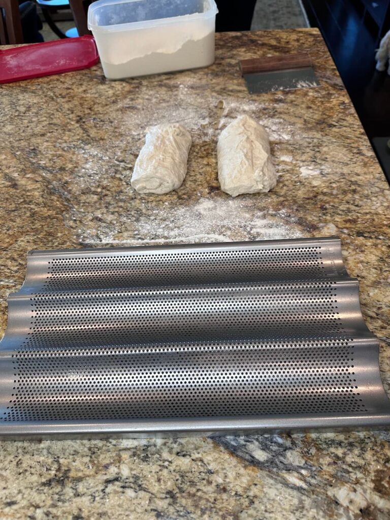 Baguette pan shown with two doughs ready to be shaped into my homemade baguettes