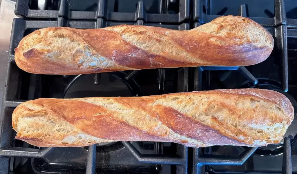 Two homemade baguettes cooling on my stove top 