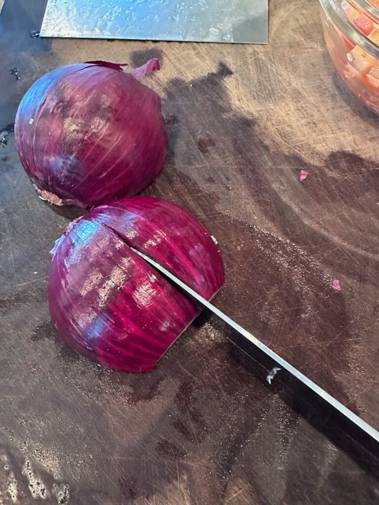 showing how to score an onion in half - in preparation for cutting to make the pieces the size I want - quarter moon