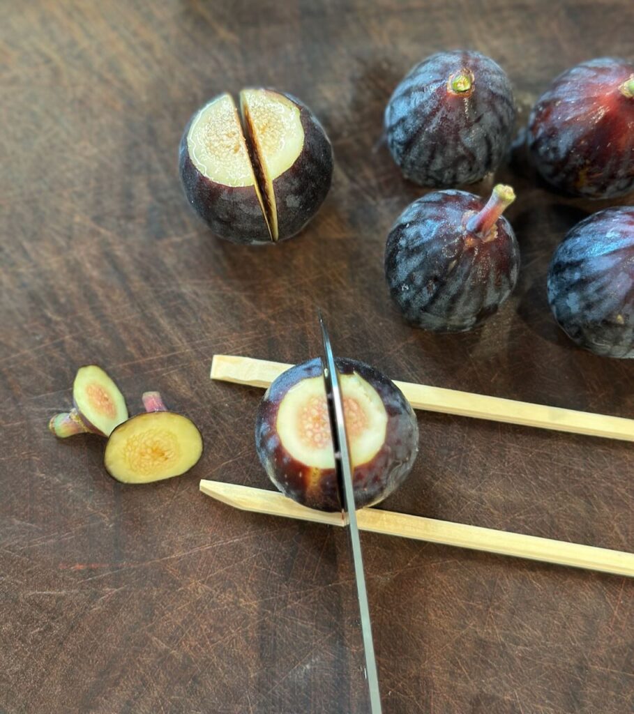 Showing how to use chop sticks to cut figs in half without slicing through the bottom