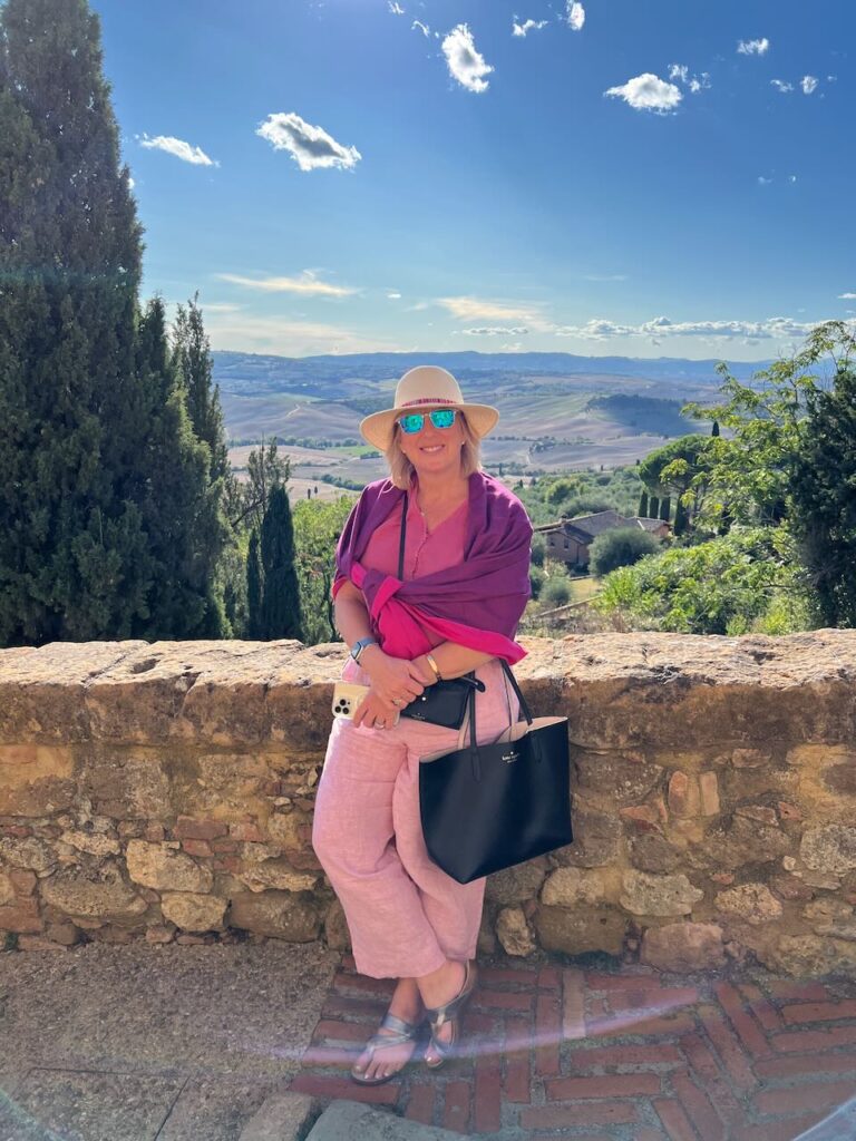 A picture of me - happy - with a beautiful view of Tuscany behind me