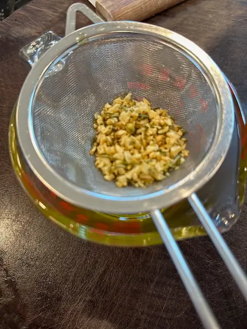A top view of Herbs and Garlic being separated from the olive oil that will be used on the potatoes to roast