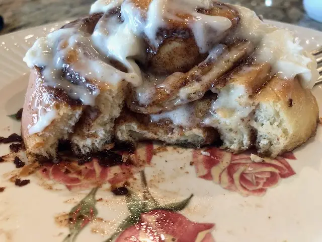 A fresh yummy cinnamon roll with a couple of bites gone