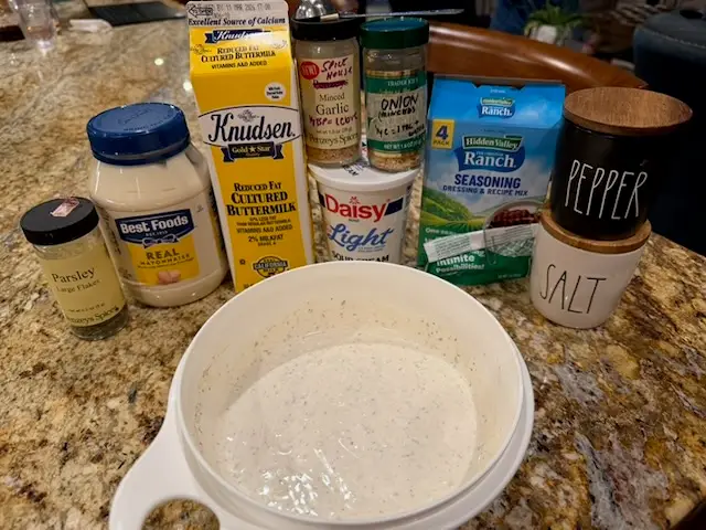 All the ingredients to make the homemade buttermilk ranch dressing are shown - along with a medium bowl and the ranch that was already made 